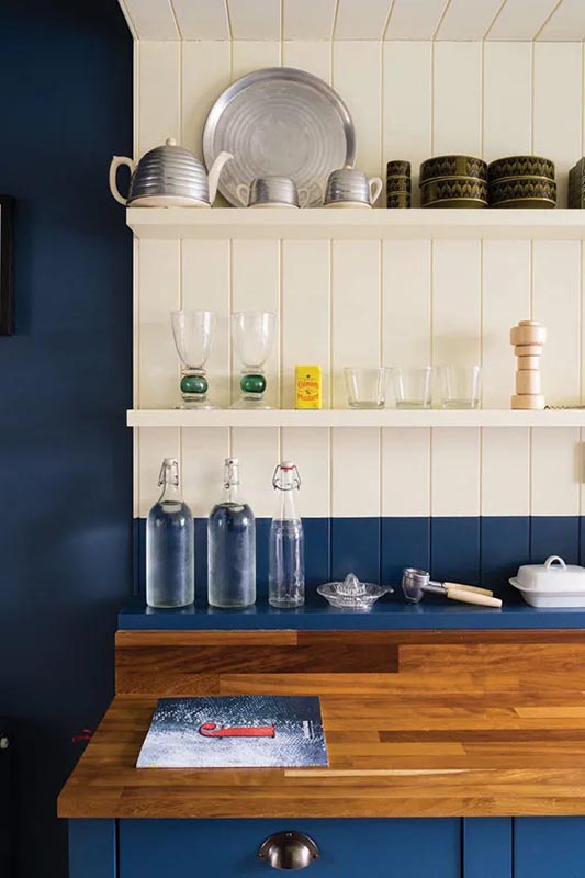 blue kitchen wall with a white back and hard wood counter.